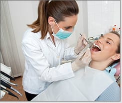 Man in dentist chair getting work done on dental implants therapy