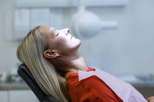Woman with blonde hair laying back in dental chair
